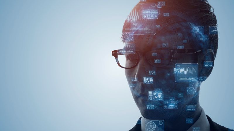 Silhouette of a man with glasses overlaid with digital data graphics