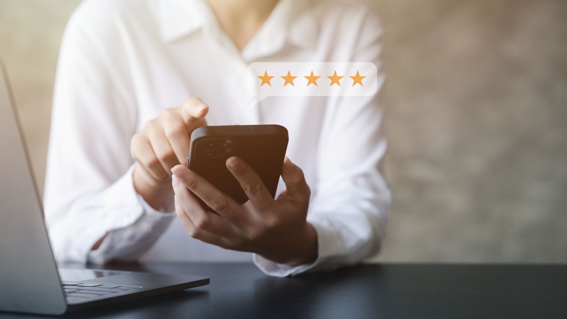 Person holding a smartphone with a five-star rating above the screen