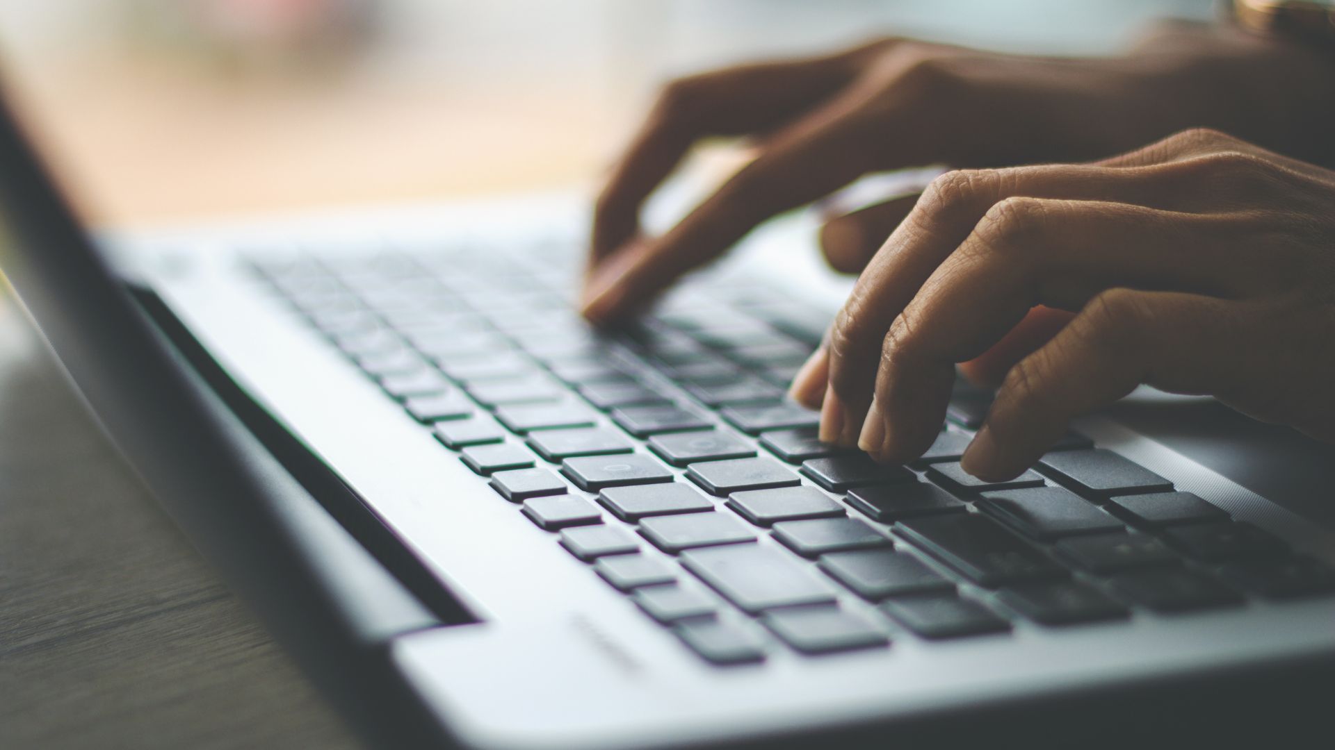 Mains tapant sur le clavier d'un ordinateur portable