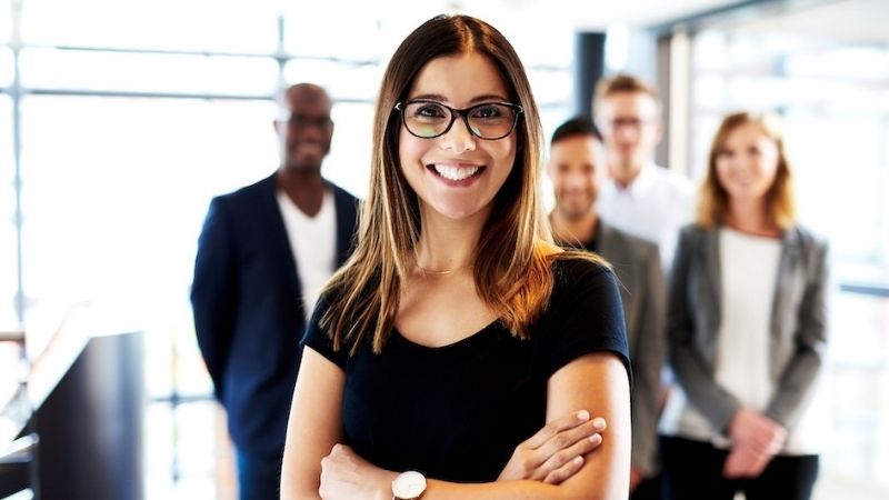 Business leader smiling with her colleagues behind her, impersonating buyer personas