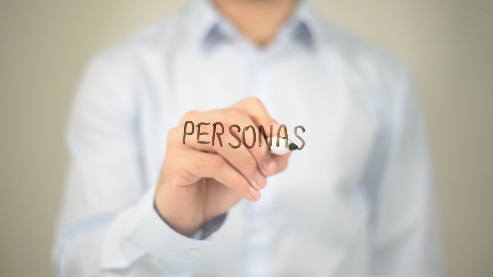 Man writing the word Personas on transparent screen