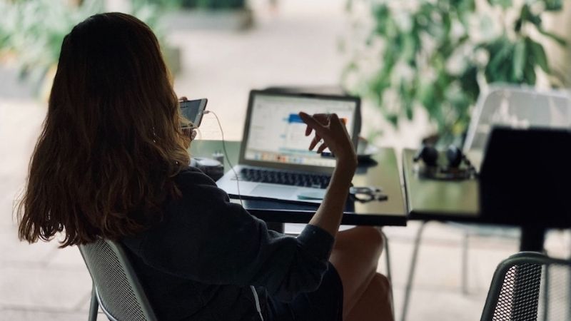 Woman sitting at her desk, holding an hands-free headset