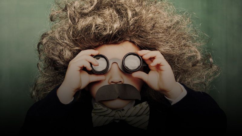 Child dressed as Albert Einstein with a wig and fake moustache