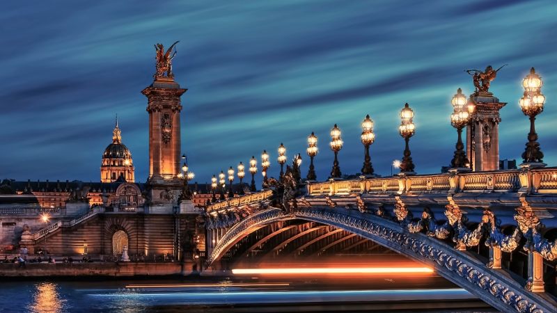 Le pont Alexandre III, un pont en arc illuminé, s'étend sur la Seine à Paris