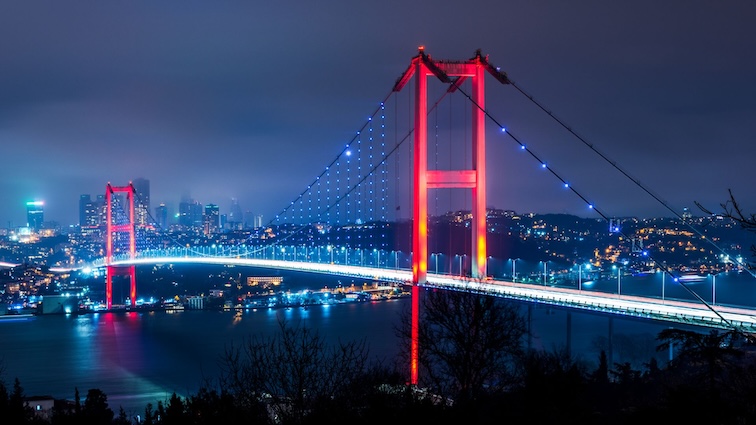 The iconic Bosphorus Bridge lit up at night, connecting Europe and Asia across the Bosphorus Strait in Istanbul