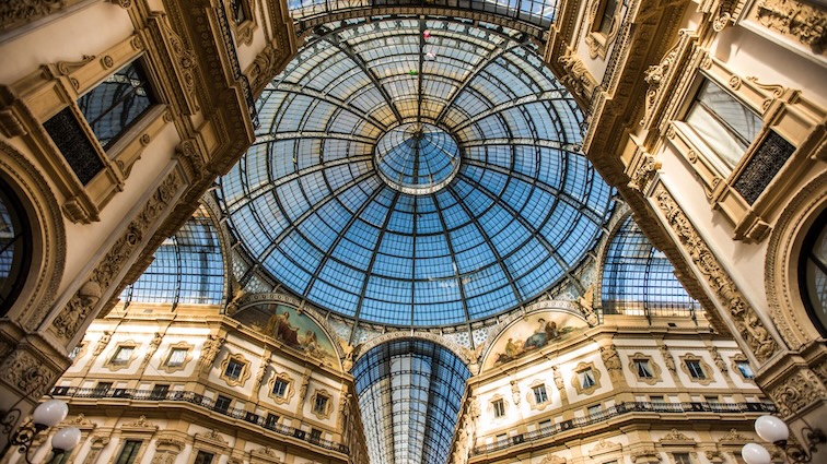 The interior of the Galleria Vittorio Emanuele II, a historic shopping gallery in Milan, with a glass dome and ornate architecture