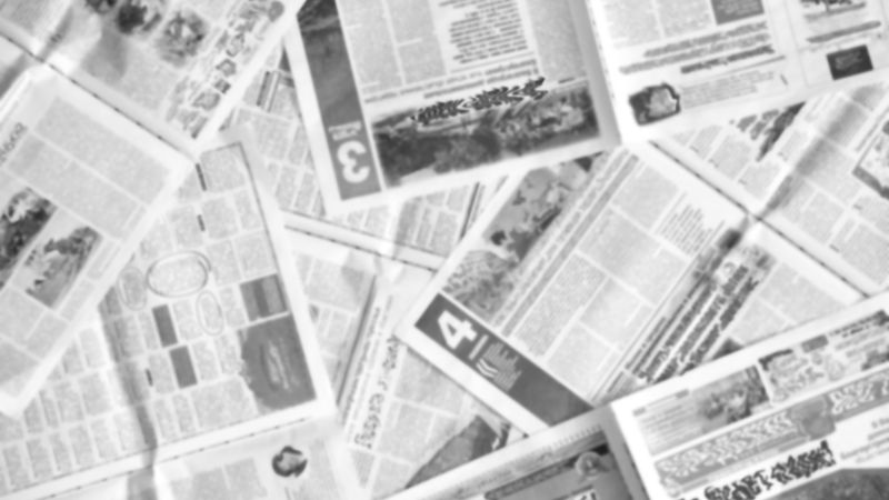 Overhead view of multiple newspapers spread out randomly