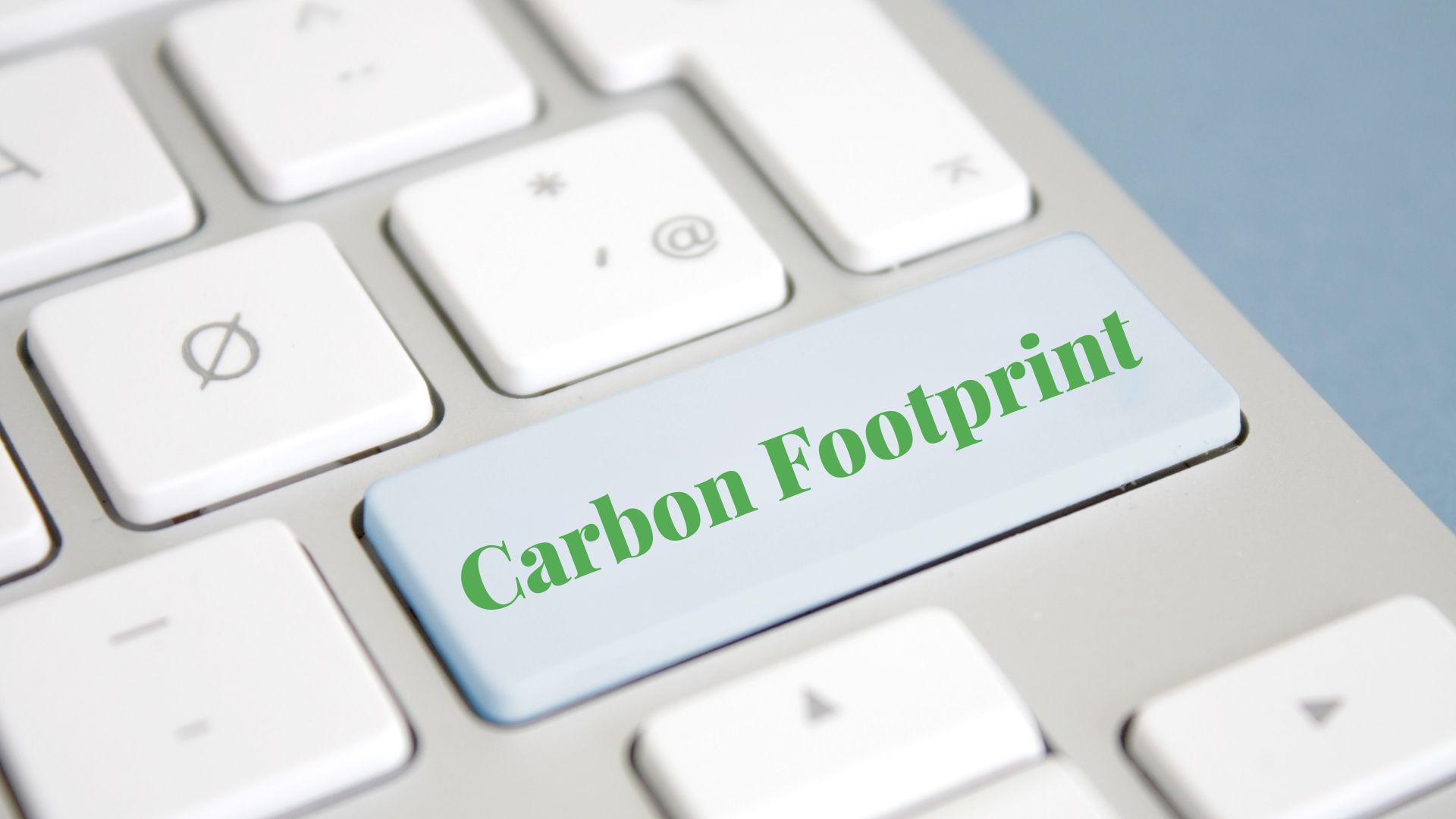 A keyboard with a light blue key labeled "Carbon Footprint" in green text, symbolizing environmental awareness and sustainability