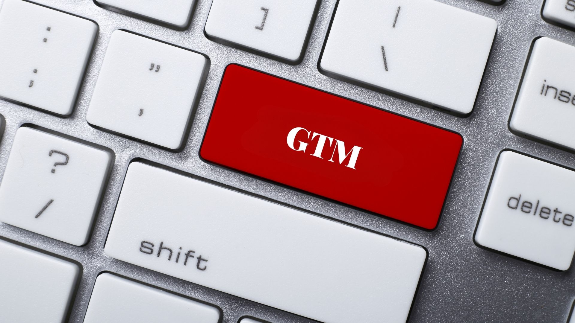 A close-up of a keyboard with a red key labeled "GTM" replacing one of the standard keys, standing for Go-To-Market Plan