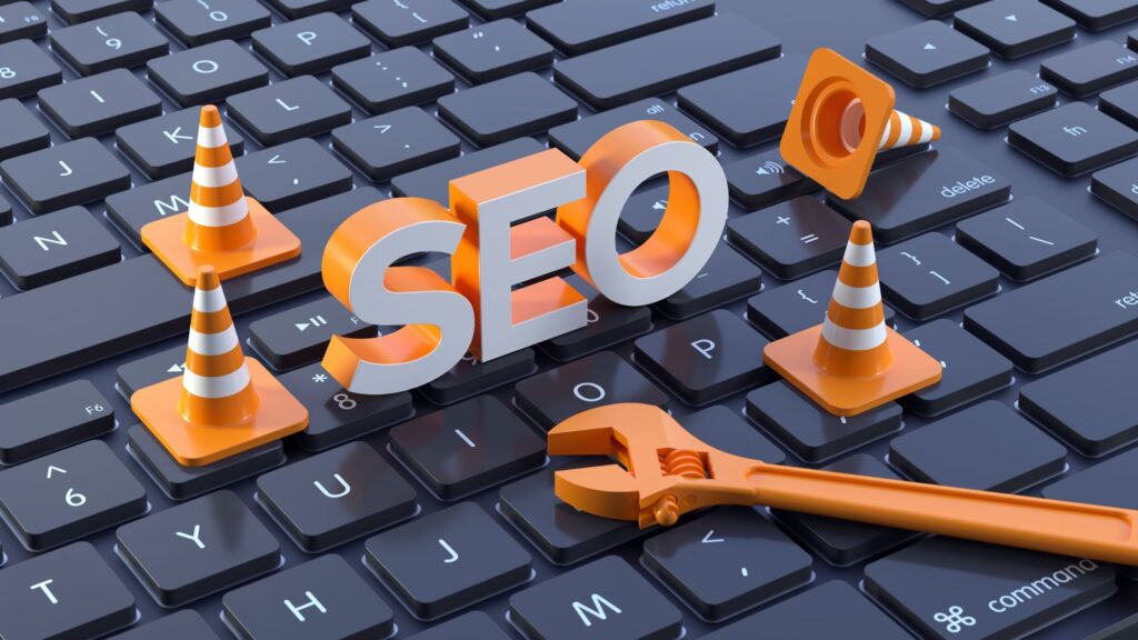SEO letters with orange traffic cones and a wrench on a computer keyboard, symbolizing website optimization and technical improvements