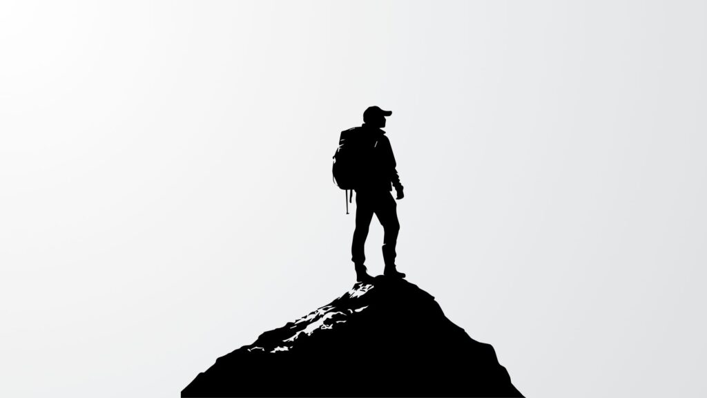 Silhouette of a person standing on a mountain peak
